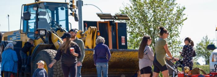 people walking in front of a loader 