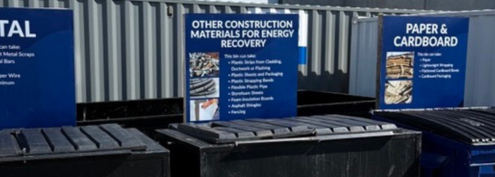 Three recycling bins at a construction site