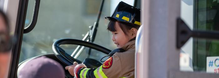 Kid behind the wheel of a fire truck