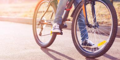 child on bicycle riding on road on a spring day