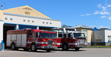 Photo of Okotoks fire department and two fire trucks parked infront