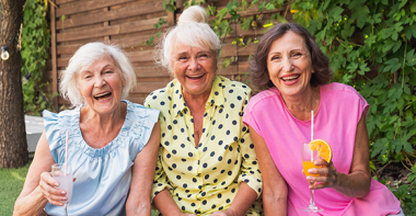 three senior women laughing in garden