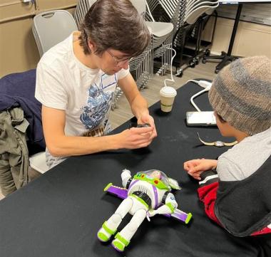 Repair Cafe volunteer helping fix a stuffed toy for a child