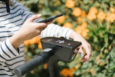 image of a person holding up phone to scan an e-scooter
